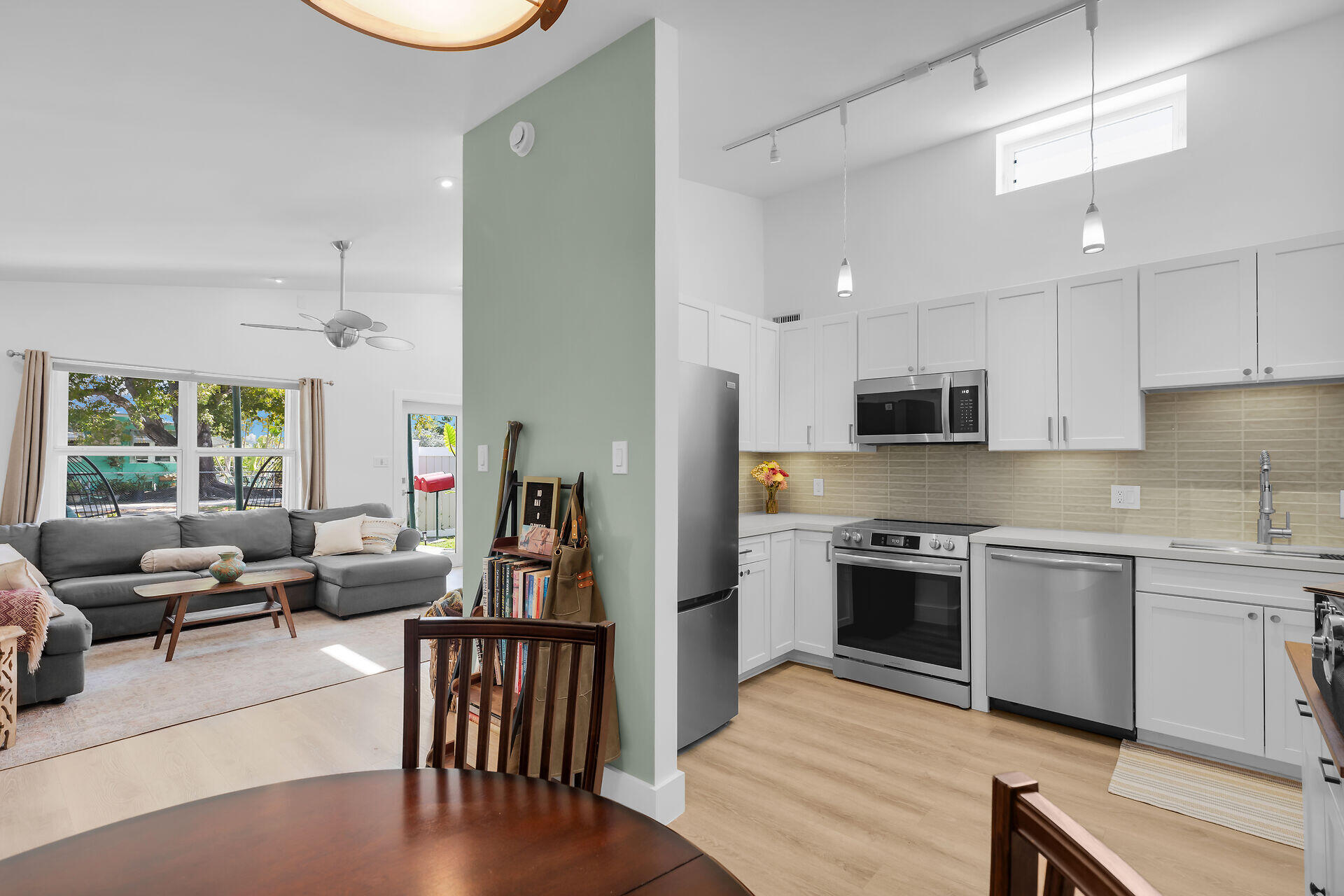1440 17th Street Key West, FL 33040 - Photo 7 of 37 a kitchen with stainless steel appliances granite countertop a stove top oven a sink dishwasher a dining table and chairs with wooden floor