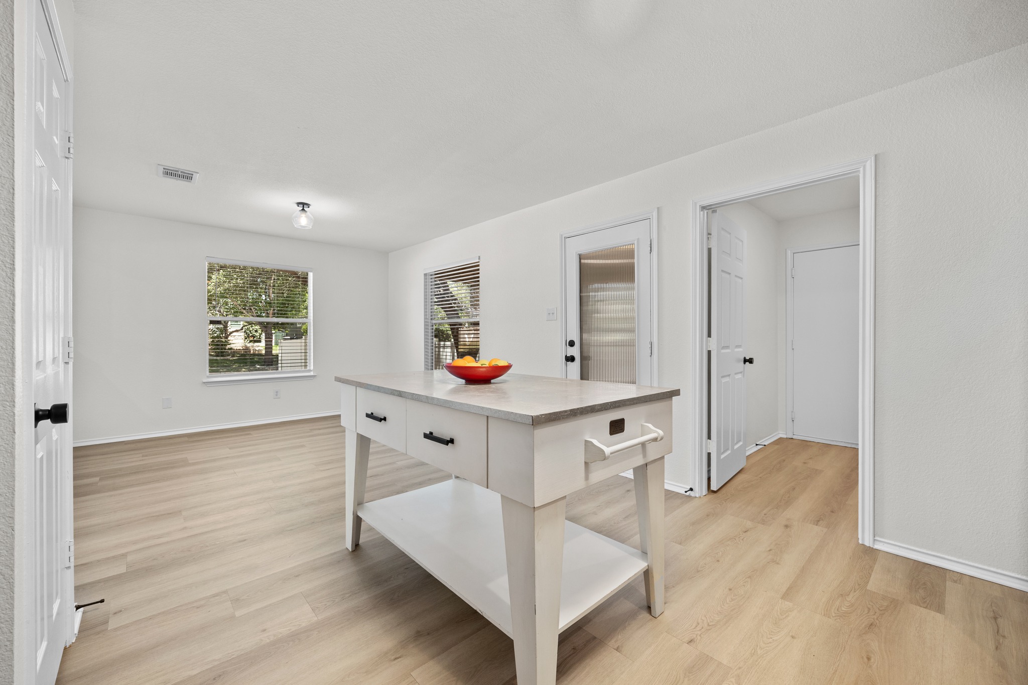 1818 Lost Maples Loop Cedar Park, TX 78613 - Photo 11 of 38 A bright open-concept space features resilient light-toned plank flooring and an adaptable kitchen island.
