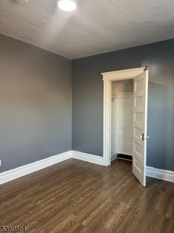 an empty room with wooden floor & closet