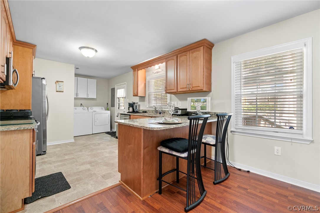6209 Walderbrook Road Richmond, VA 23234 - Photo 11 of 35 a kitchen with a table chairs refrigerator and wooden cabinets