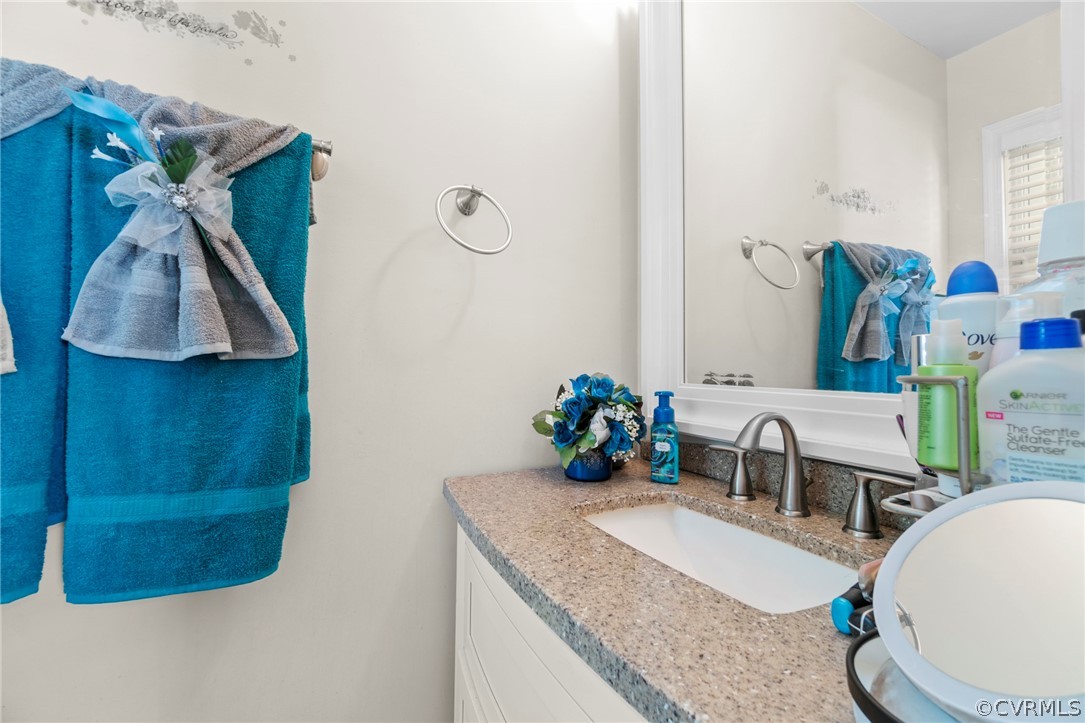 6209 Walderbrook Road Richmond, VA 23234 - Photo 21 of 35 a bathroom with a granite countertop sink a toilet and a mirror