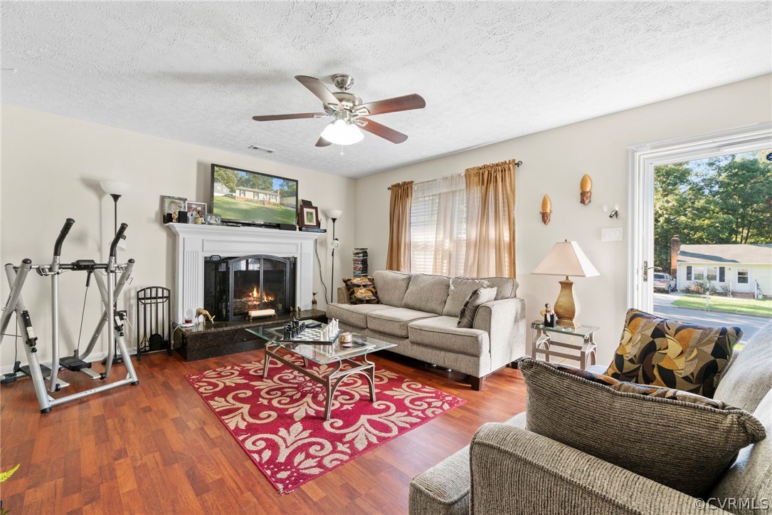 6209 Walderbrook Road Richmond, VA 23234 - Photo 3 of 35 a living room with furniture a flat screen tv and a fireplace