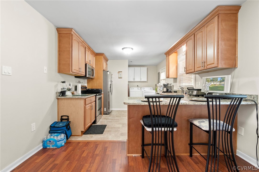6209 Walderbrook Road Richmond, VA 23234 - Photo 10 of 35 a kitchen with stainless steel appliances granite countertop a dining table chairs microwave and sink