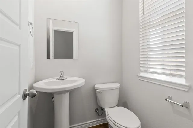 a bathroom with a sink a toilet and mirror