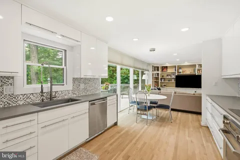 a kitchen with stainless steel appliances granite countertop a sink and stove top oven with wooden floor