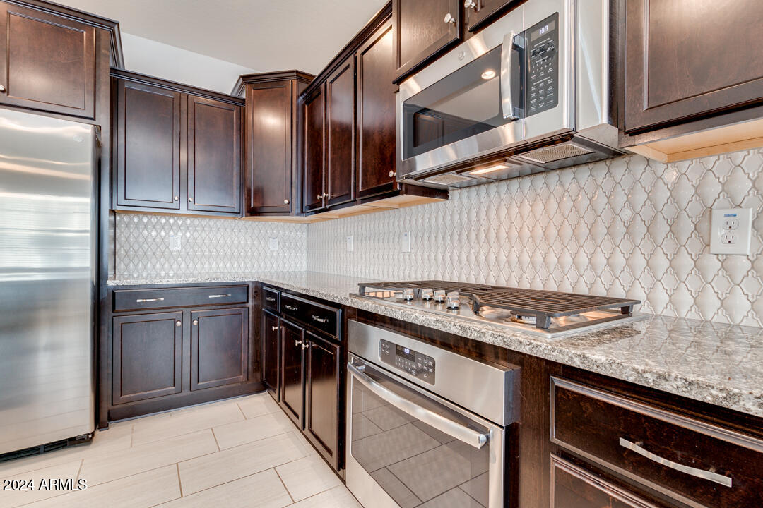 3661 East STILES Lane Gilbert, AZ 85295 - Photo 13 of 38 a kitchen with stainless steel appliances granite countertop a stove and a microwave