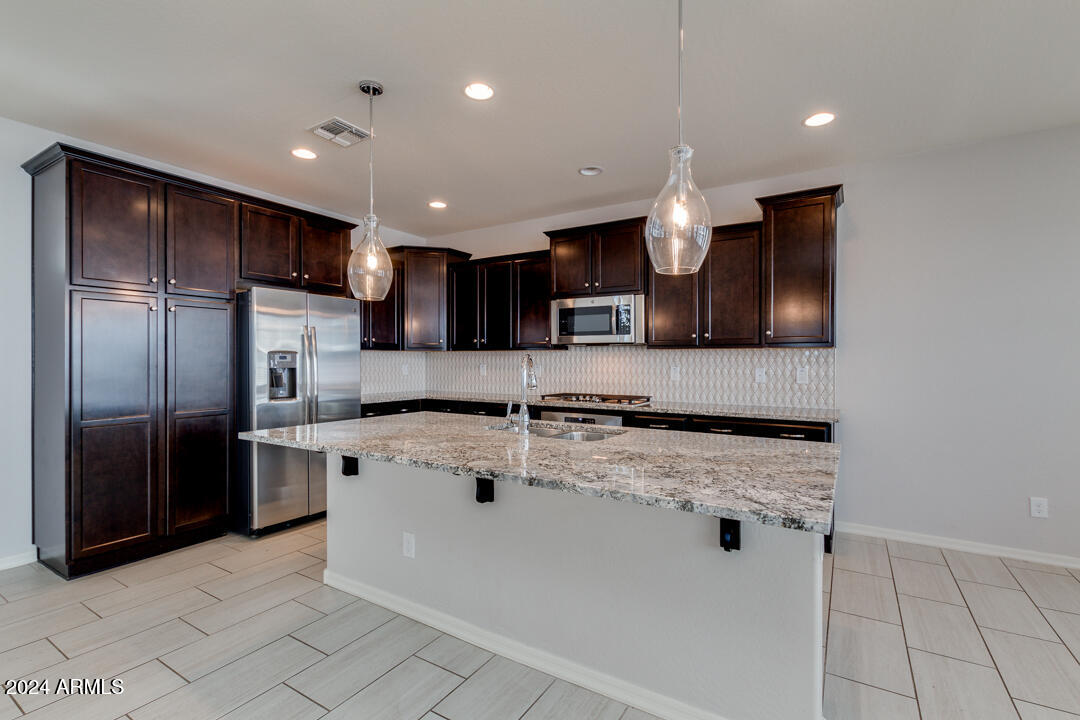 3661 East STILES Lane Gilbert, AZ 85295 - Photo 6 of 38 a kitchen with stainless steel appliances granite countertop a sink a stove and a refrigerator