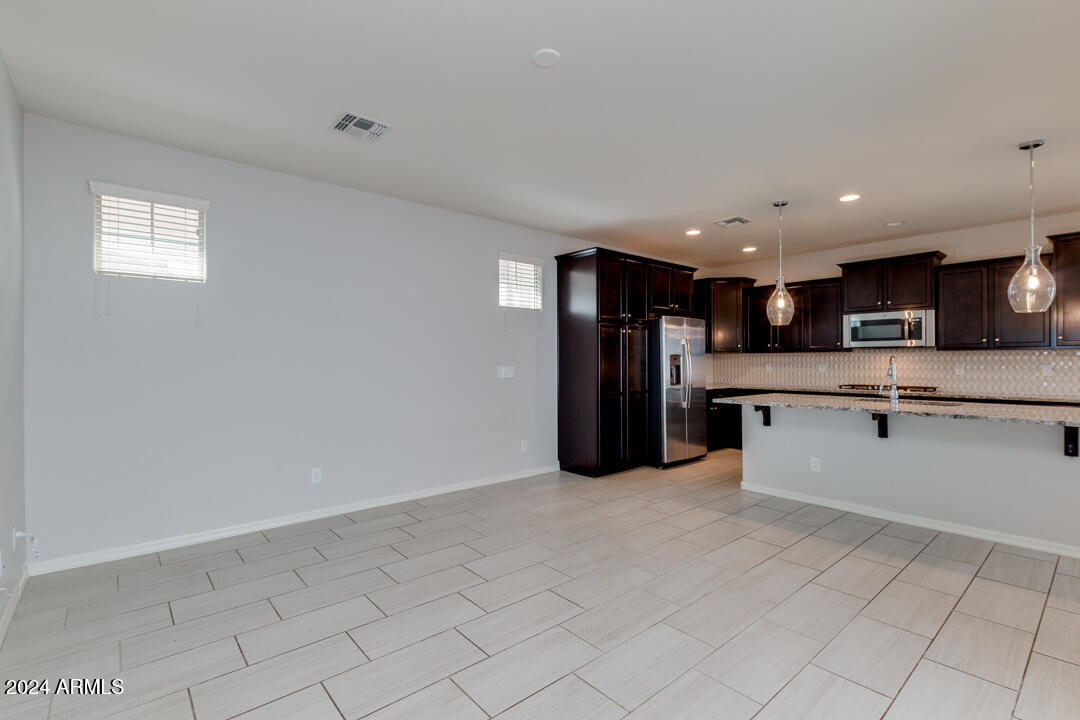 3661 East STILES Lane Gilbert, AZ 85295 - Photo 7 of 38 a kitchen with stainless steel appliances kitchen island granite countertop a refrigerator and a sink