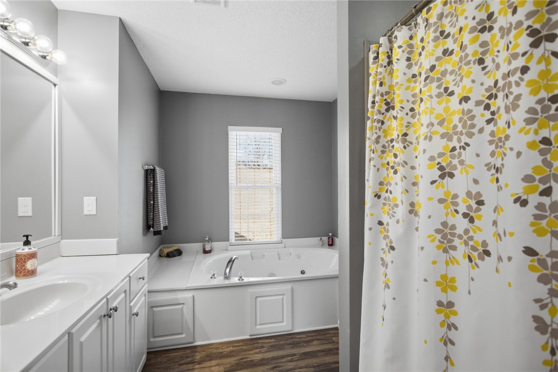158 State Rd S-37-175 Seneca, SC 29672 - Photo 18 of 43 This bathroom features a double vanity and a built-in soaking tub, offering comfort and style.