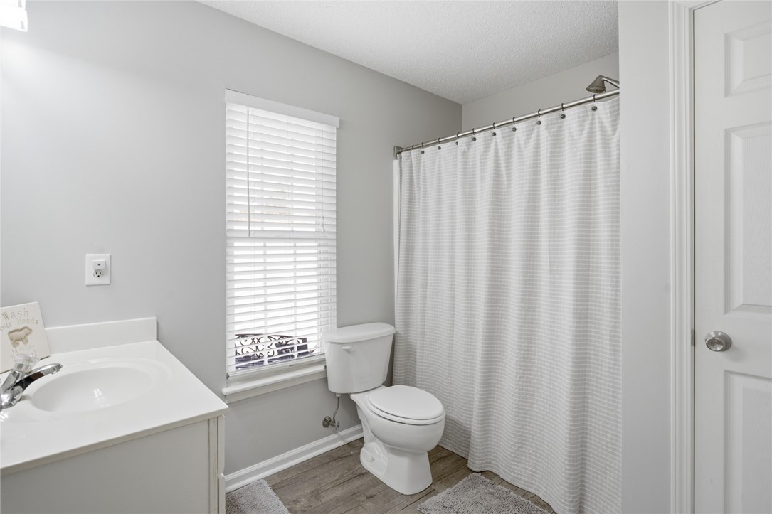 158 State Rd S-37-175 Seneca, SC 29672 - Photo 25 of 43 This bathroom features a sleek vanity, modern toilet, and a window for natural light.