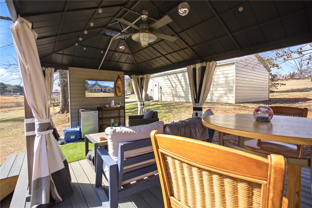 158 State Rd S-37-175 Seneca, SC 29672 - Photo 31 of 43 This spacious covered patio provides an inviting outdoor entertainment area, perfect for relaxation and gatherings.
