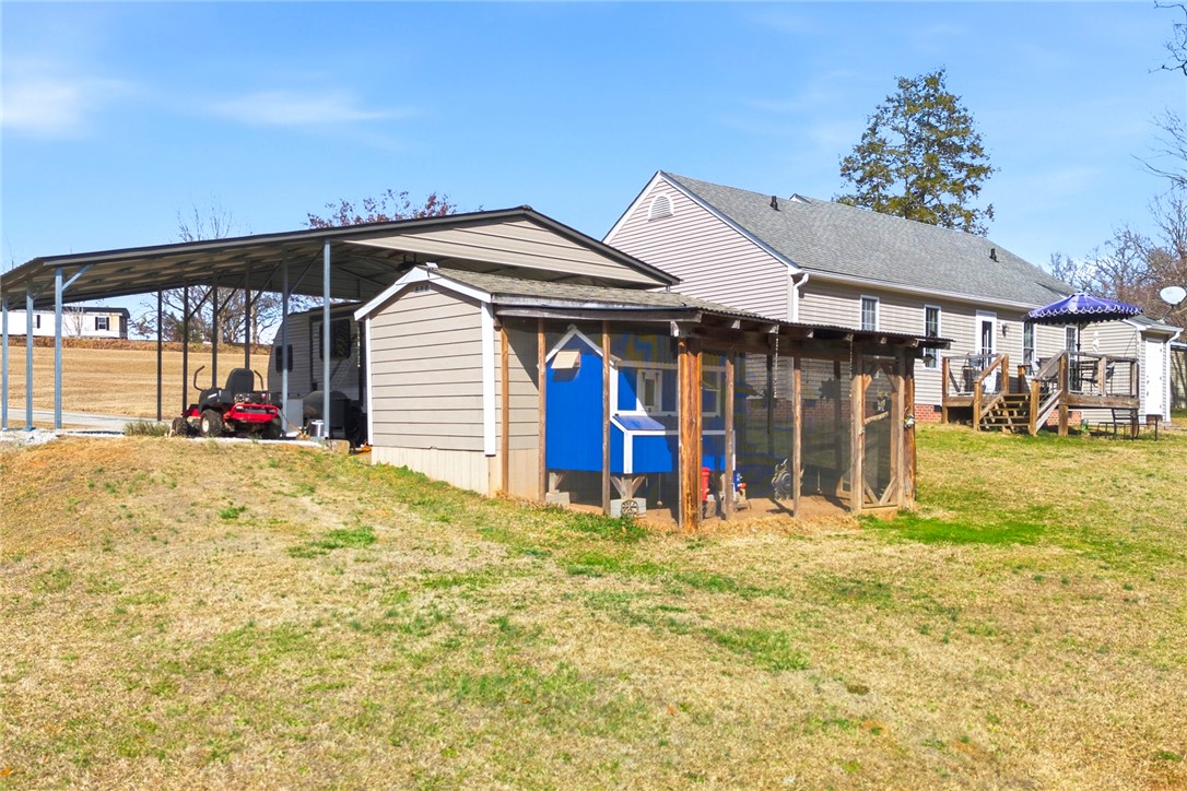 158 State Rd S-37-175 Seneca, SC 29672 - Photo 40 of 43 This spacious backyard features a versatile carport and a charming chicken coop, offering practical outdoor living.