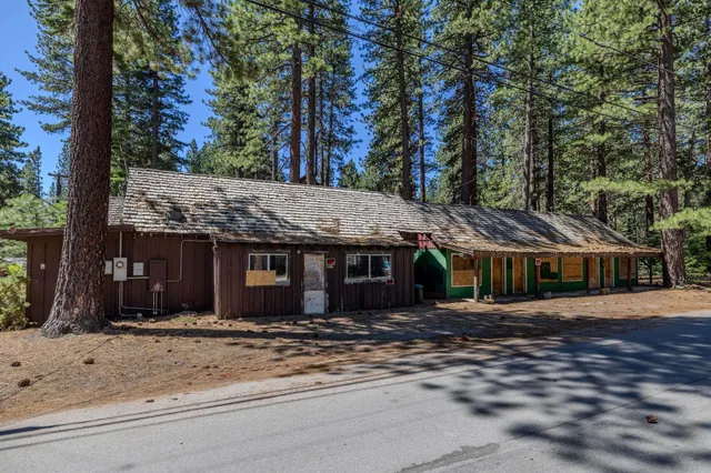 a front view of a house with a yard and tree s