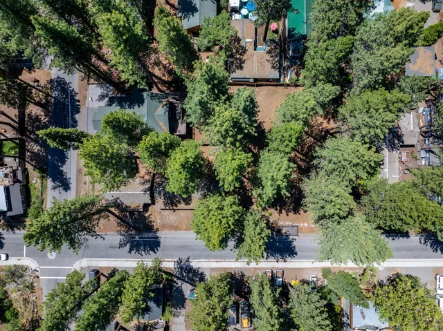 an aerial view of a house with a yard and lake