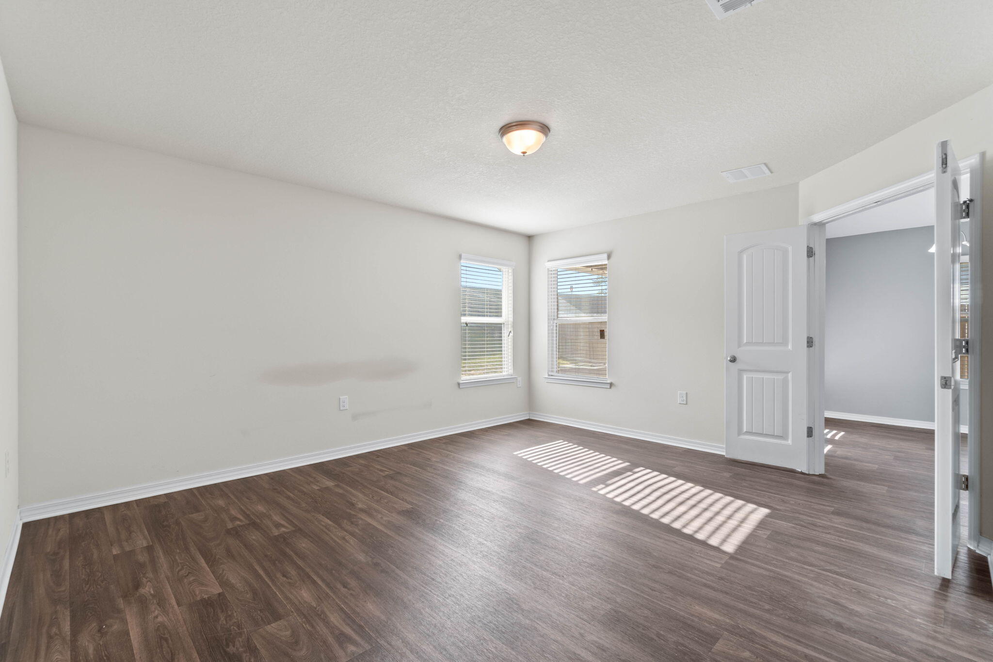 229 Croft Circle Crestview, FL 32536 - Photo 11 of 22 an empty room with wooden floor & windows