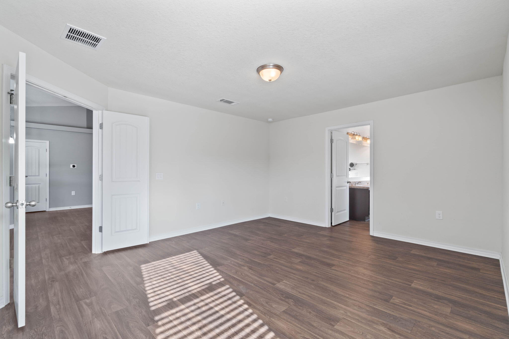 229 Croft Circle Crestview, FL 32536 - Photo 12 of 22 a view of an empty room with wooden floor and a bathroom