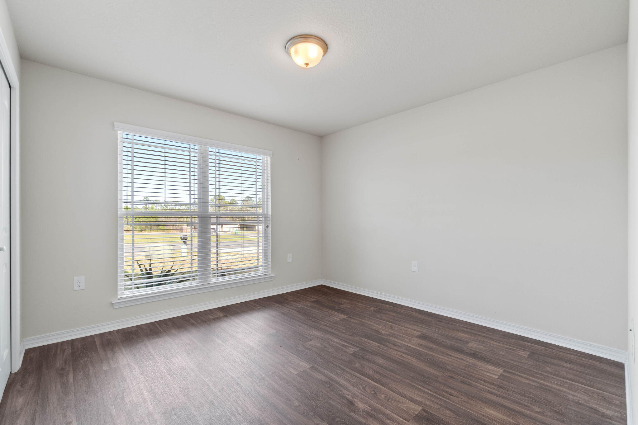 229 Croft Circle Crestview, FL 32536 - Photo 15 of 22 an empty room with wooden floor and windows