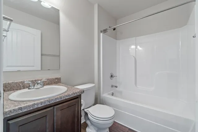 a bathroom with a granite countertop sink mirror vanity and toilet