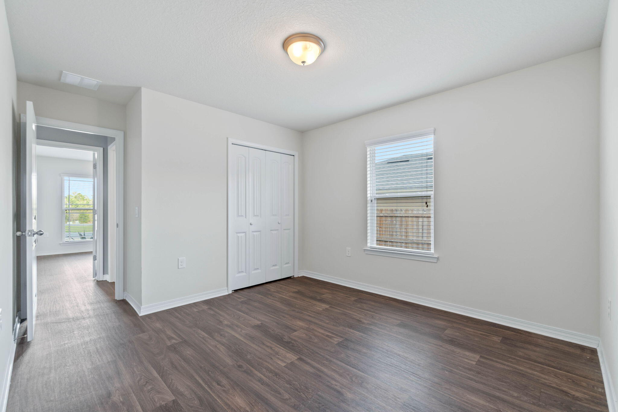 229 Croft Circle Crestview, FL 32536 - Photo 19 of 22 an empty room with wooden floor and windows