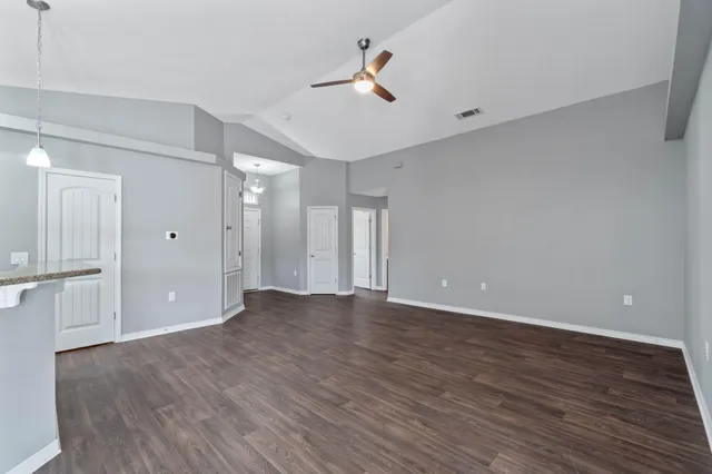 a view of an empty room with wooden floor