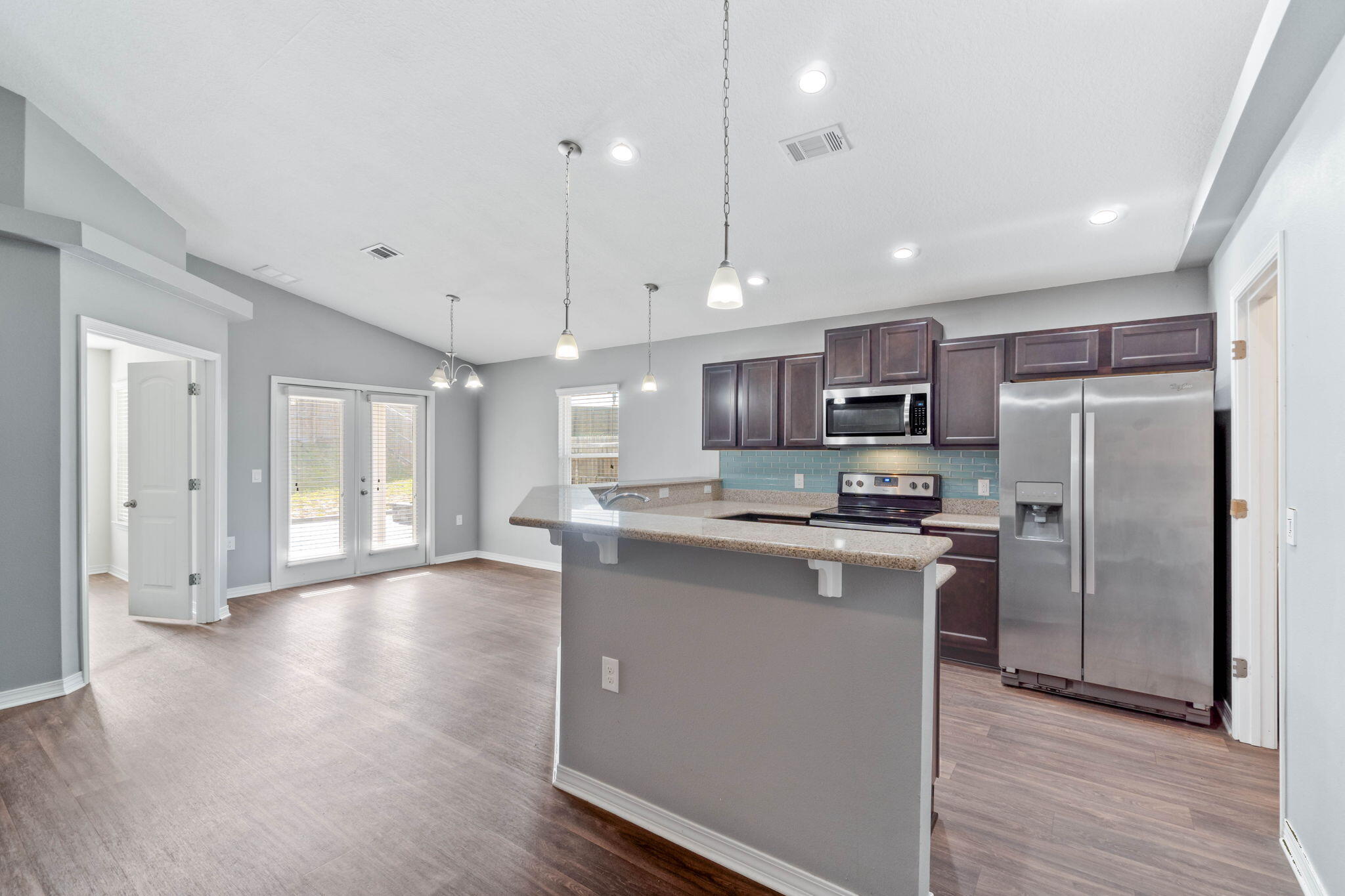 229 Croft Circle Crestview, FL 32536 - Photo 5 of 22 a kitchen with stainless steel appliances granite countertop a refrigerator a sink dishwasher a stove and white cabinets with wooden floor