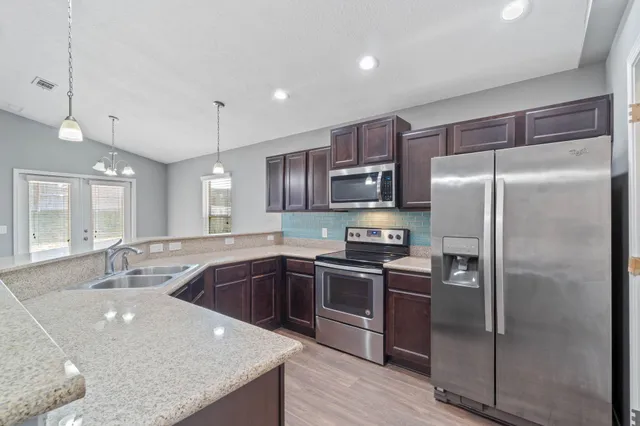 a kitchen with kitchen island a sink stove and refrigerator