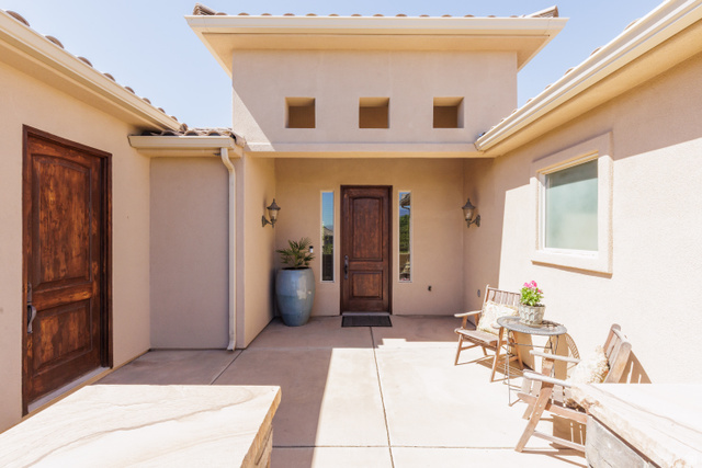 1257 West 2320 South St. George, UT 84770 - Photo 2 of 55 Entry courtyard featuring a solid wood door, stucco exterior, distinct square window accents, and tiled roofline