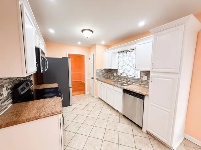 a kitchen with stainless steel appliances granite countertop a refrigerator and a stove