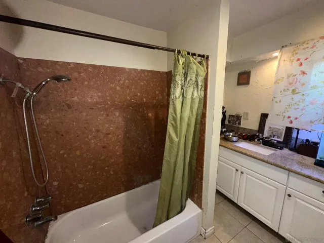 a bathroom with a granite countertop sink a mirror and shower