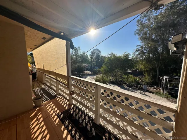 a view of balcony with wooden floor and fence