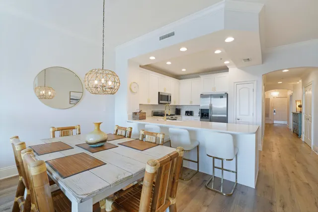 a view of a dining room and a kitchen with a table chairs