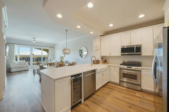 a kitchen with stainless steel appliances granite countertop a refrigerator a stove a sink and a microwave