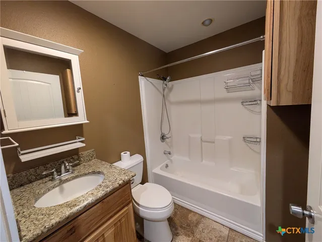 a bathroom with a granite countertop sink toilet and shower