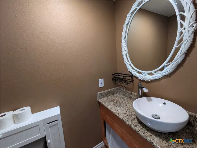 a bathroom with a granite countertop sink and mirror