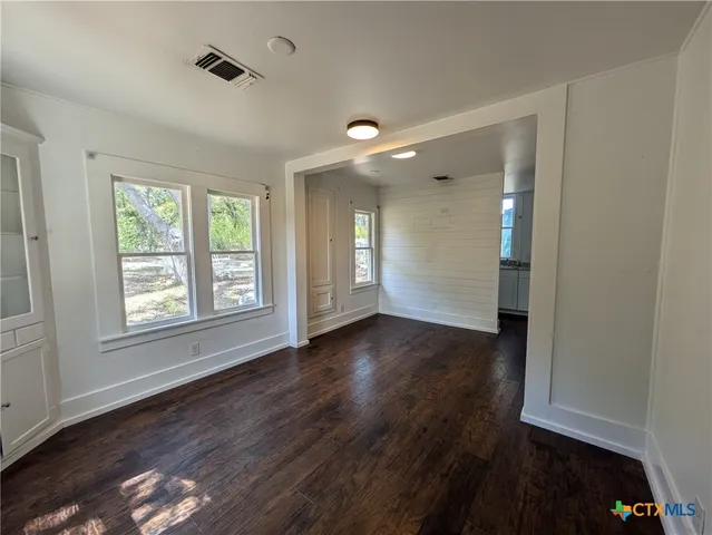 a kitchen with stainless steel appliances granite countertop white cabinets and window