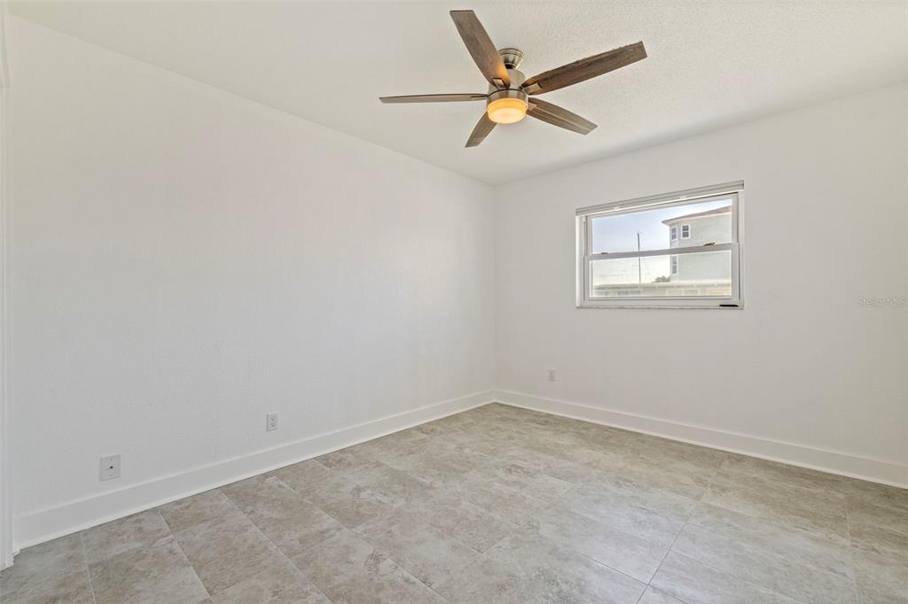176 175th Avenue East Redington Shores, FL 33708 - Photo 19 of 37 an empty room with a window and a fan