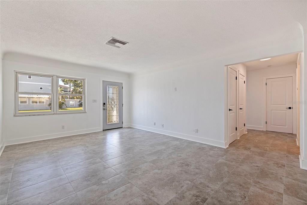 176 175th Avenue East Redington Shores, FL 33708 - Photo 3 of 37 a view of an empty room with a window and wooden floor