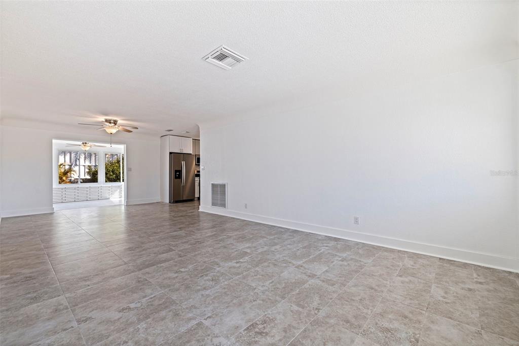 176 175th Avenue East Redington Shores, FL 33708 - Photo 5 of 37 a view of a livingroom with wooden floor and a refrigerator