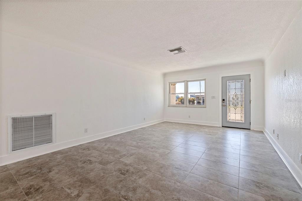 176 175th Avenue East Redington Shores, FL 33708 - Photo 6 of 37 an empty room with windows and mirror