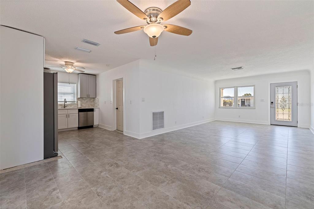 176 175th Avenue East Redington Shores, FL 33708 - Photo 9 of 37 a view of an empty room with a window and kitchen view