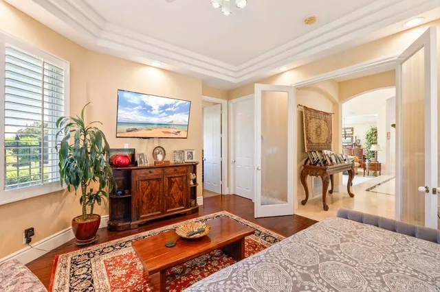 a bedroom with a bed couches and a large window with outer view