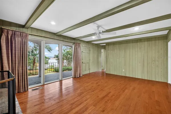 a view of an empty room with a window and kitchen