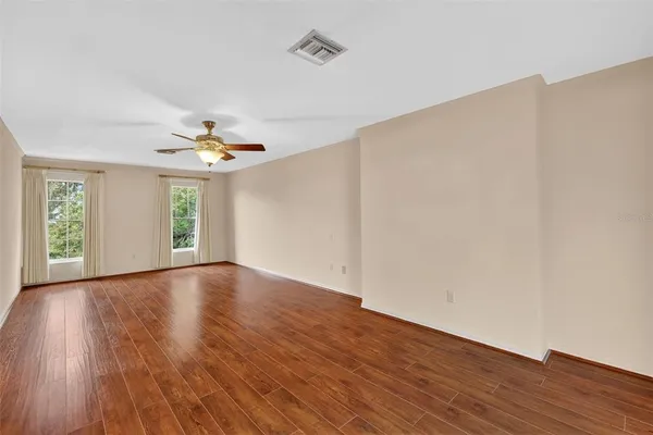 a view of a refrigerator in kitchen and an empty room
