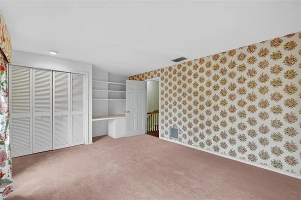 a view of an empty room with kitchen and a window