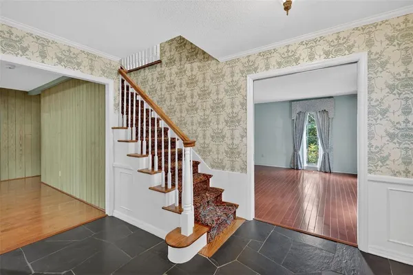 an empty room with wooden floor fireplace and windows