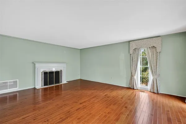 a view of an empty room with wooden floor