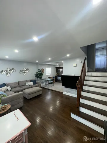 a living room with furniture a wooden floor and a large window
