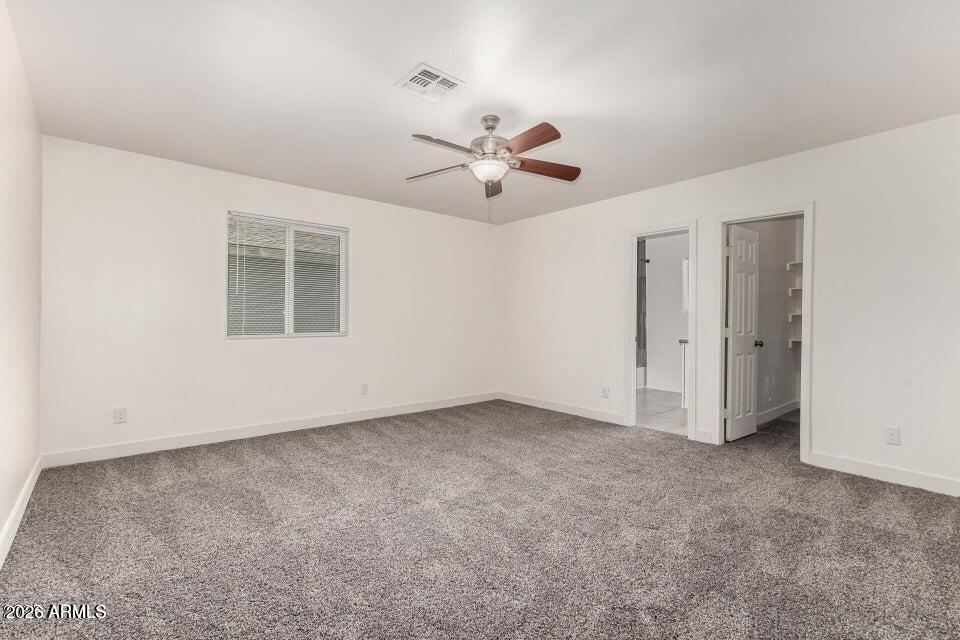 2828 East Chipman Road Phoenix, AZ 85040 - Photo 10 of 26 an empty room with chandelier fan and windows