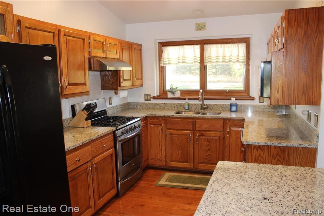 5417 Eagle Road Highland, MI 48356 - Photo 8 of 44 Granite counter tops with stainless steal stove, dishwasher and microwave