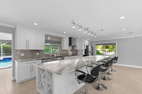 a kitchen with kitchen island a sink table and chairs